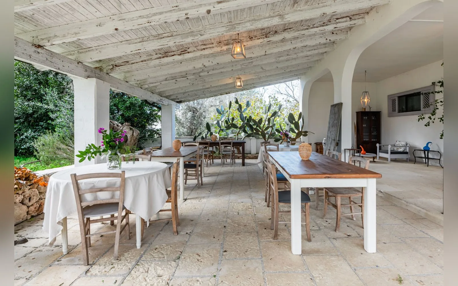 Uno spazio esterno coperto dell'agriturismo, con i tavoli apparecchiati